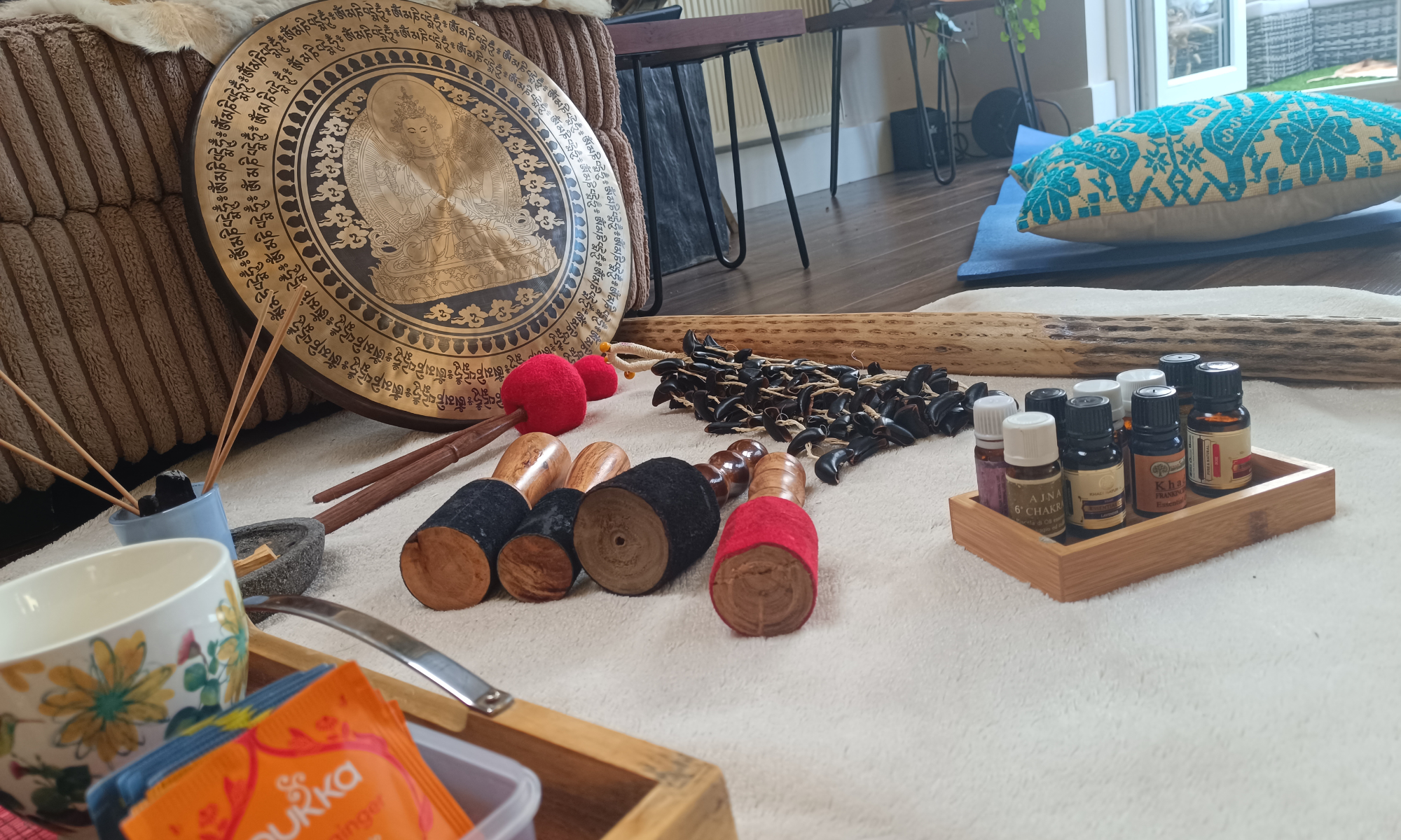 A gong with a set of gong mallets alongside it, and several types of tea.