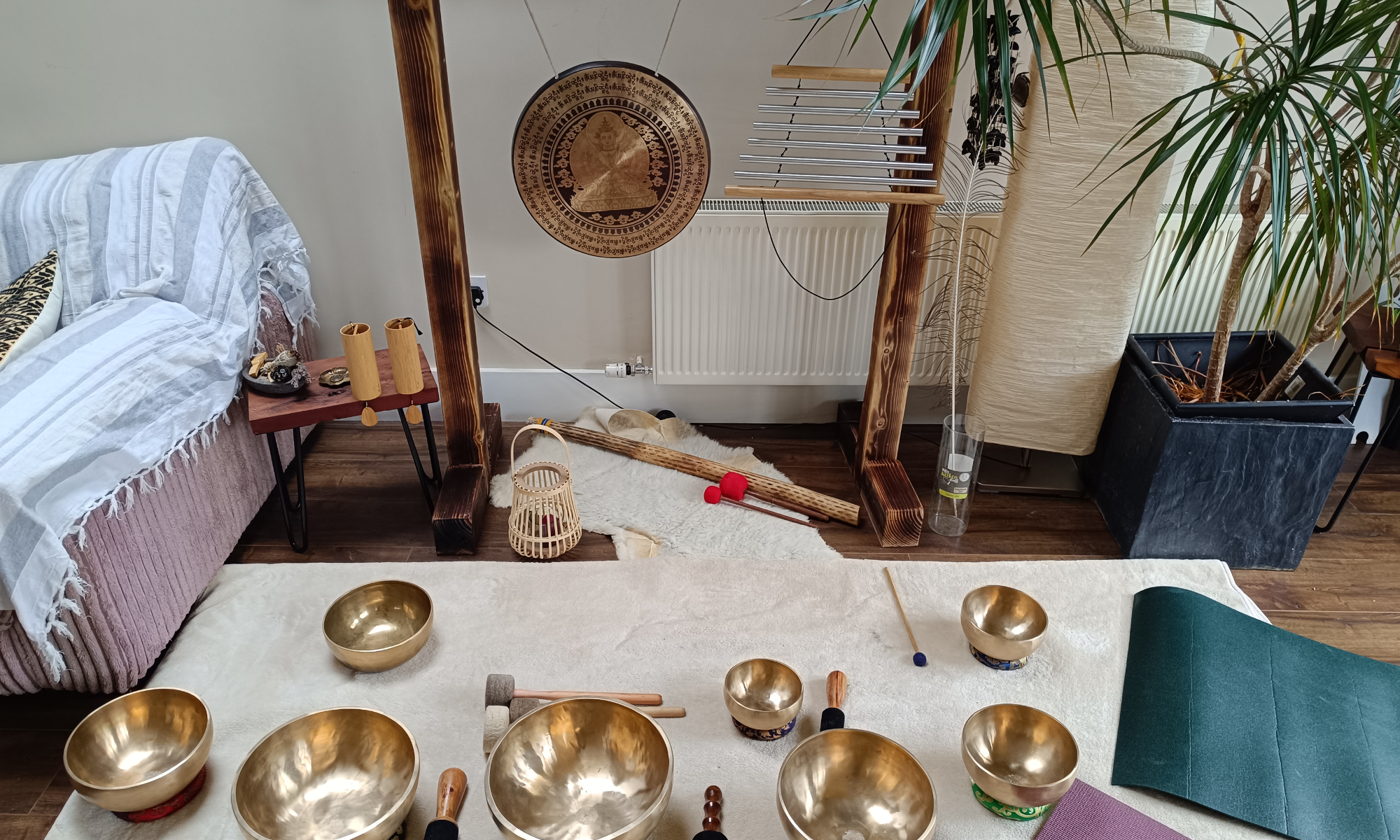 A set of sound healing instruments, featuring a gong and various himalayan bowls.