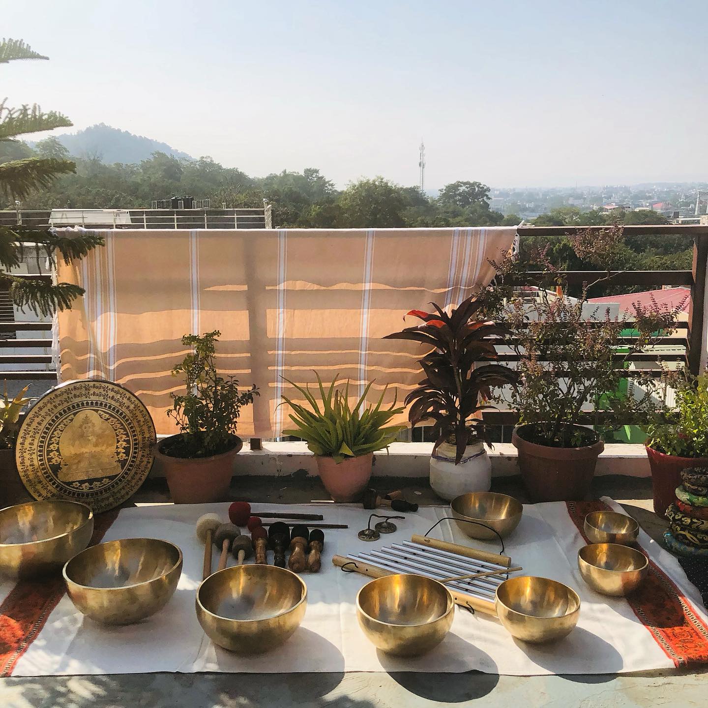 A display of sound healing instruments in a balcony, including himalayan bowls and a gong.